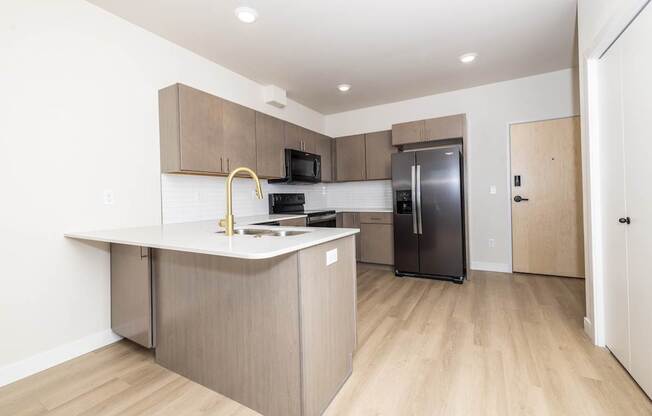 A kitchen with a refrigerator, microwave, and oven.