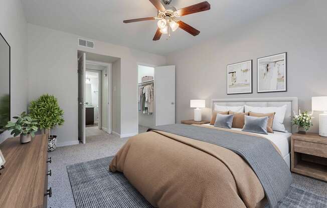 A bedroom with a large bed and a ceiling fan.