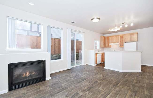 A living room with a fireplace and wooden floors.
