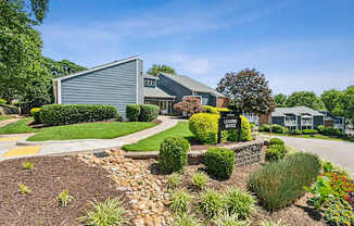A well-maintained garden surrounds a building with a sign that reads "LEADERSHIP OFFICE".