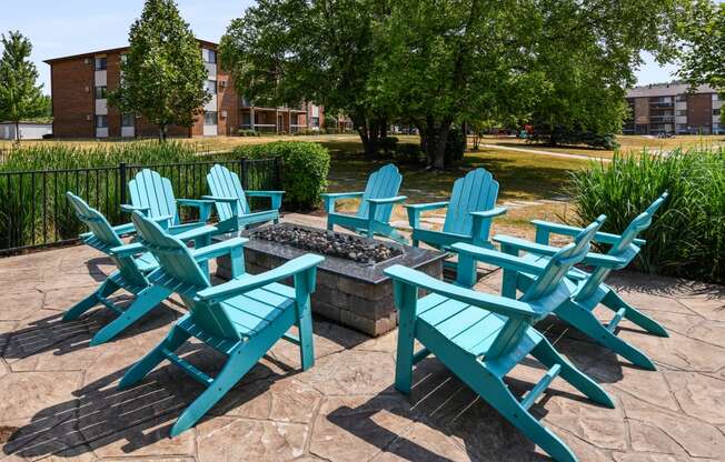 a patio with adirondack chairs and a fire pit
