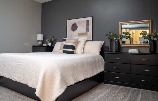 a bedroom with black furniture and a white bed