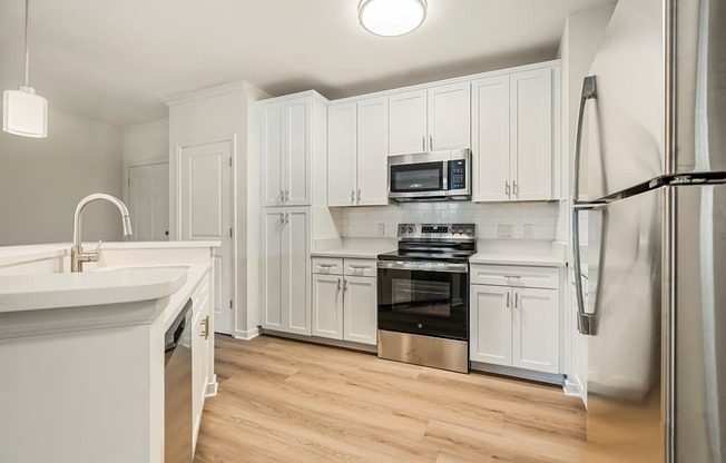 A kitchen with white cabinets and stainless steel appliances.