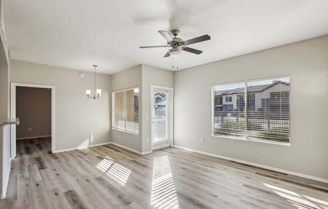 A spacious room with a ceiling fan and wooden flooring.