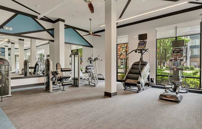 a gym with exercise equipment and windows at the estates apartments