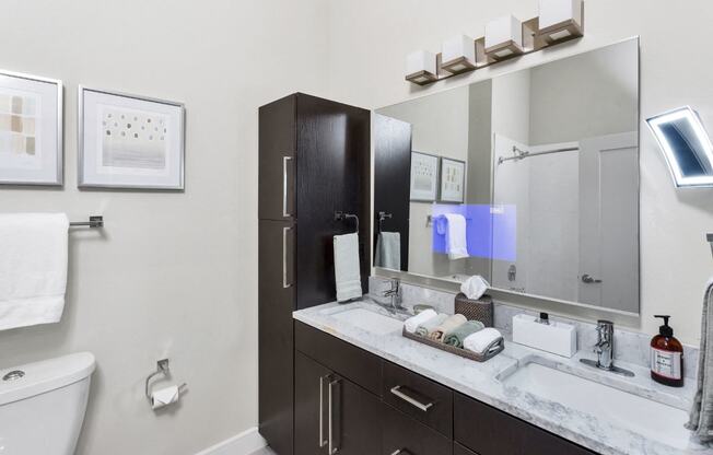Westwood Green Apartments Bathroom Vanity with embedded tv in mirror and quarts countertop with 2 undermount sinks
