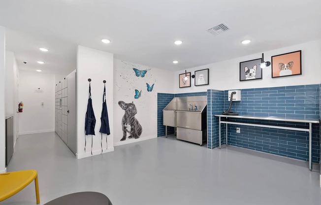 A pet washing room with a yellow bench and pictures on the wall of dogs and a large stainless steel dog washing tub.