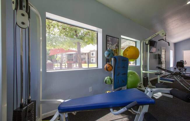 a gym with a window and a blue exercise bench
