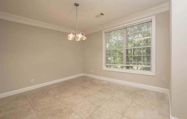 A room with a window and a chandelier.