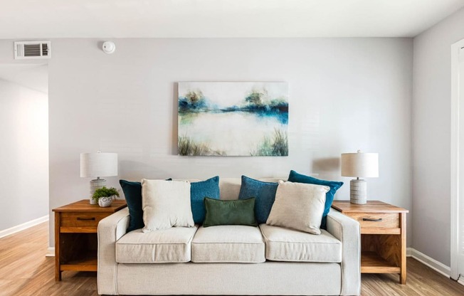 a living room with a couch and a painting on the wall