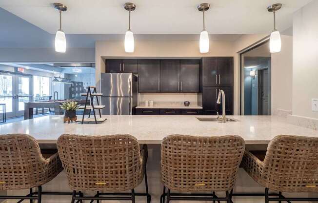 A chic kitchen area with bar seating, pendant lights, and stainless steel appliances.