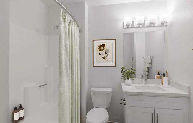 A white bathroom with a toilet, sink, and shower.