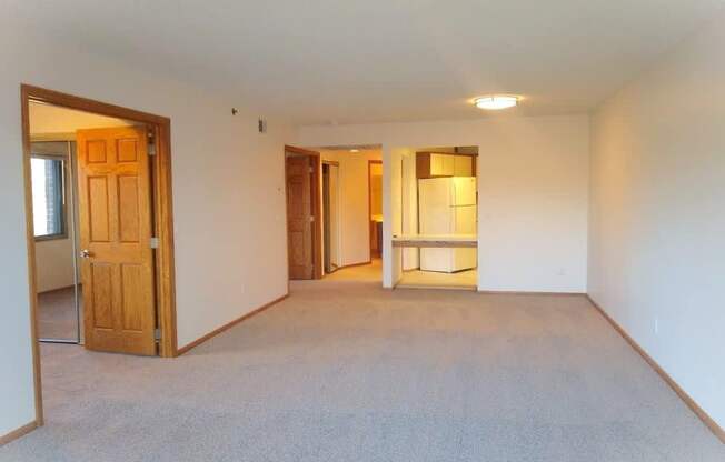 A room with a carpeted floor and a door on the left side.