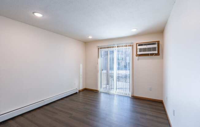 a living room with a glass sliding door. Fargo, ND Westwood Apartments