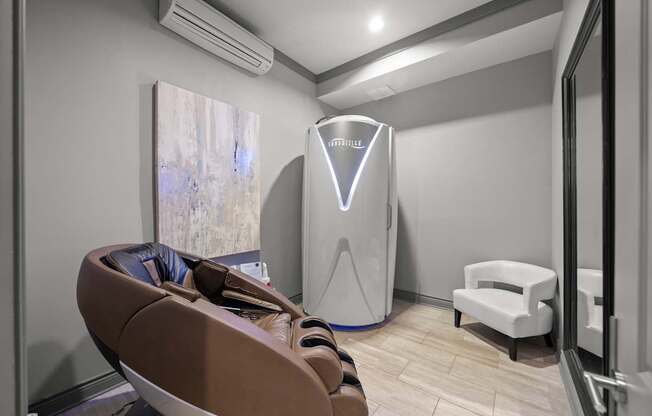 A room with a brown chair and a white cabinet.