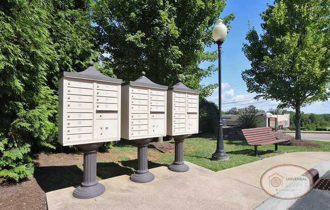 A row of mailboxes next to a bench.