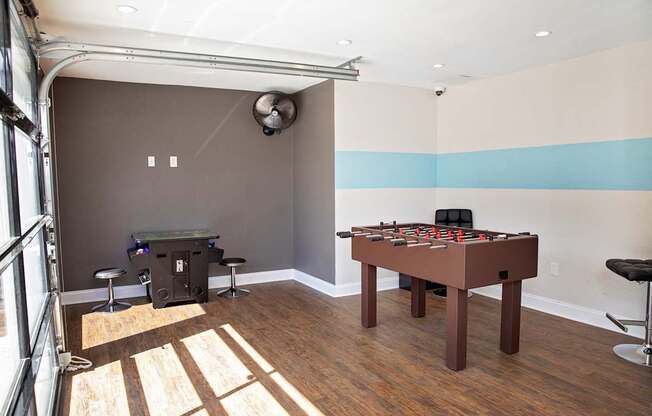 game room with a foosball table and a bar stool.