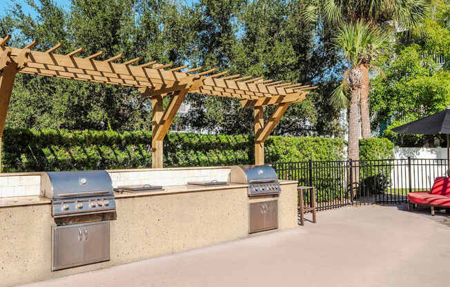 Community grill station with twin stainless grills under pergola