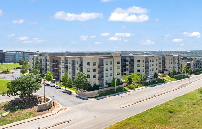 A road with a sidewalk and a grassy area with a tree.