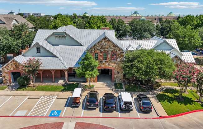 an aerial view of a parking lot with cars in front of a building