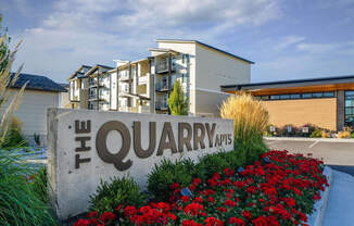 a sign for the quarry apartments in front of a building