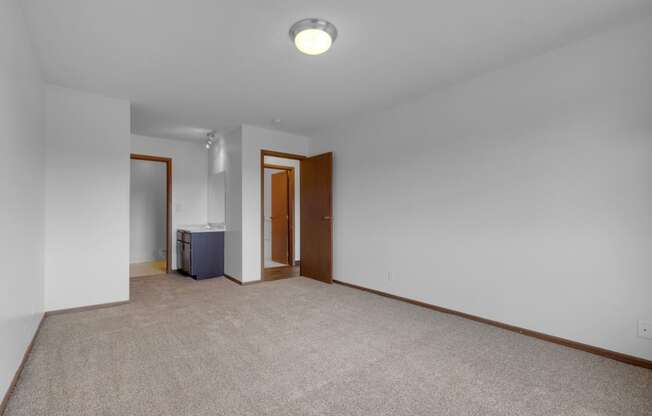 a bedroom with white walls and a beige carpet