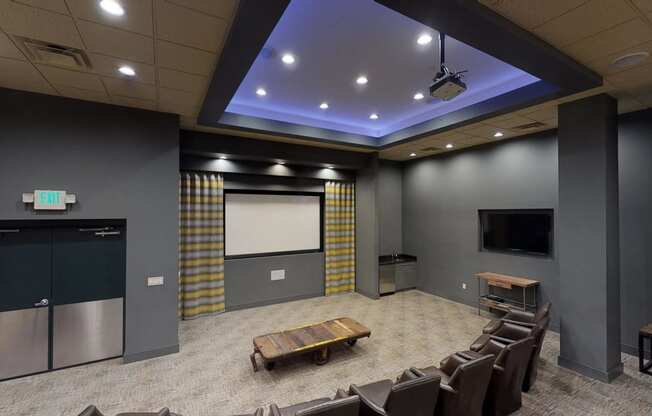 a large room with a projector screen and chairs