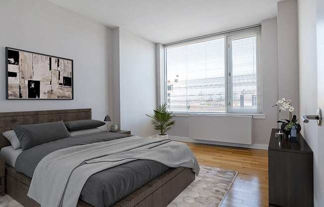 an apartment bedroom with a bed and a large window