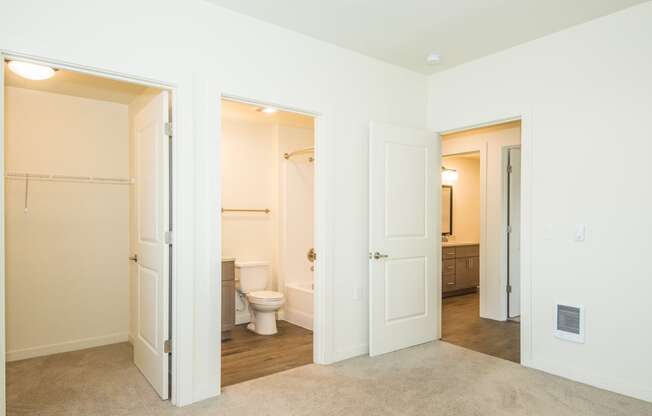 a bedroom with two closets and a bathroom with a toilet