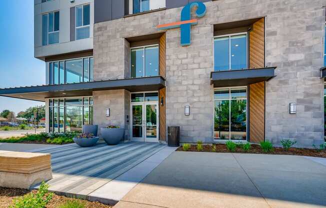 the facade of a building with large glass doors and a sidewalk in front of it