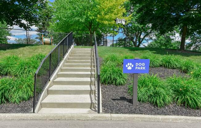 a dog park sign in front of a set of stairs