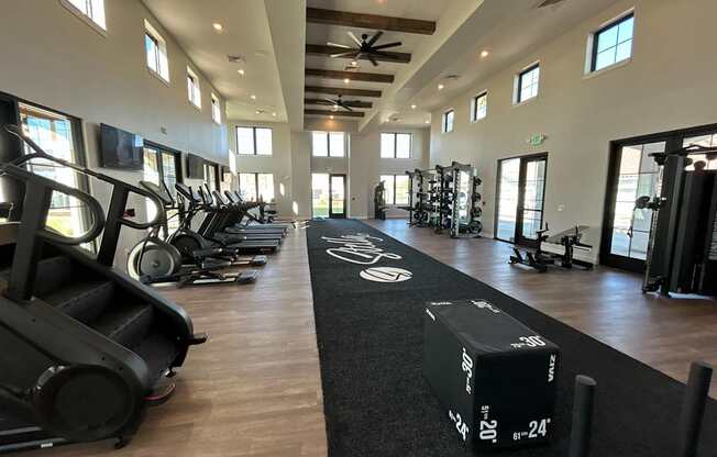 A gym with treadmills, elliptical machines, and other exercise equipment.