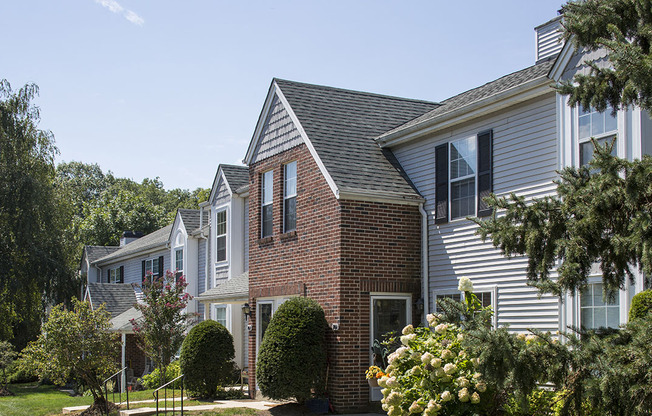 Exterior of Westridge Gardens with tall tress and beautiful bushes on a sunny day