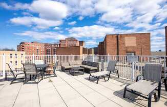 A patio with chairs and a table is set up on a rooftop.