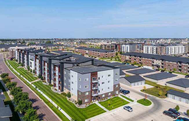 A large apartment complex with a parking lot in front.