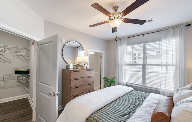 a bedroom with a large bed and a ceiling fan