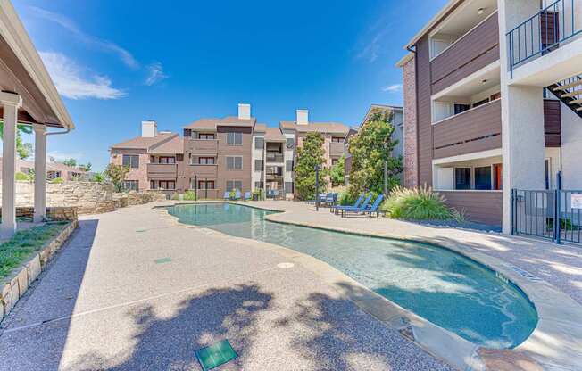 A swimming pool in a residential area surrounded by buildings.