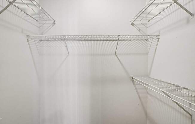 Empty wire shelves in a white room.