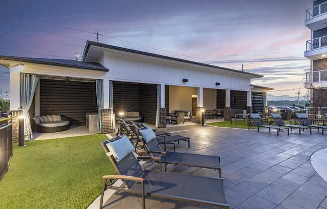 a patio with chairs and tables and a building in the background
