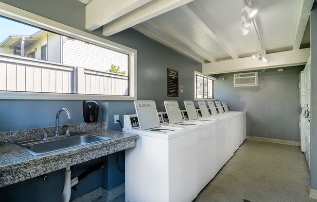 A public restroom with a row of sinks and mirrors.