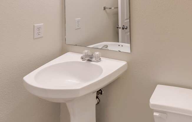 a bathroom with a sink and a mirror and a toilet