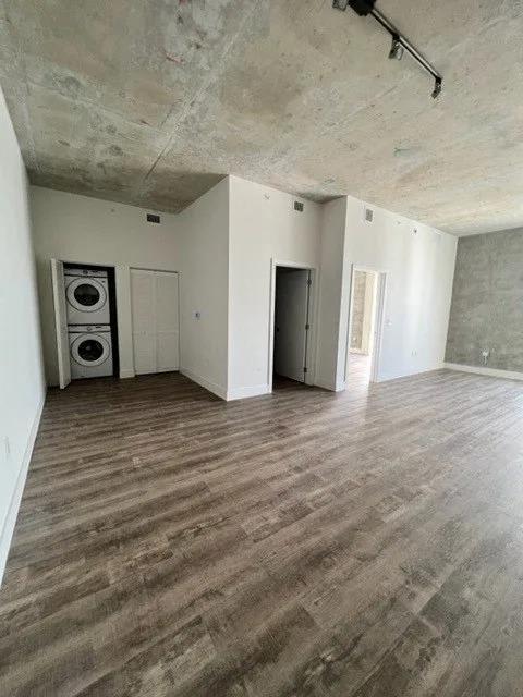 an empty living room with white walls and wood floors