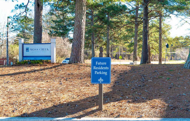 A sign for future residents parking stands in front of a Moss Creek sign.