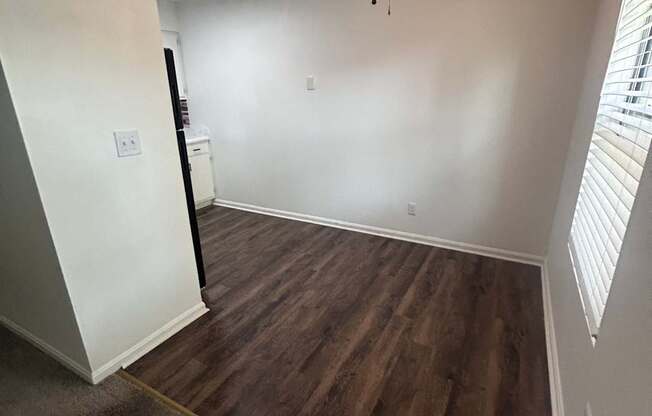 A ceiling fan is mounted on a wall in a room with a wooden staircase.