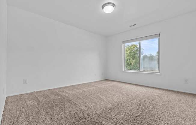 an empty room with carpet and a window at Edge At Farmington Hills - Farmington Hills, MI, Farmington Hills, 48334
