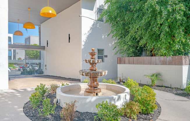 a fountain in a courtyard in front of a building at The Flats on Addison, Sherman Oaks