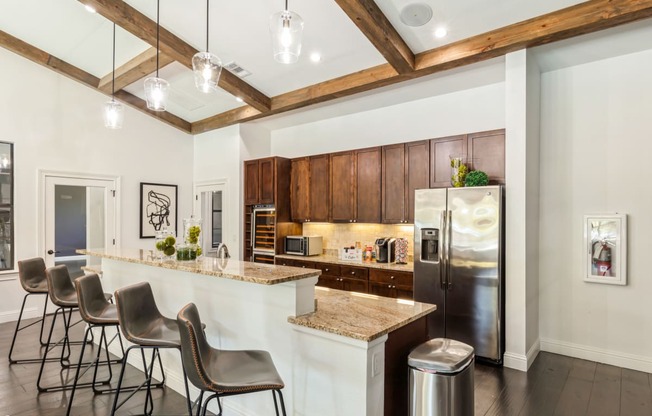 a kitchen with a bar and chairs and a refrigerator