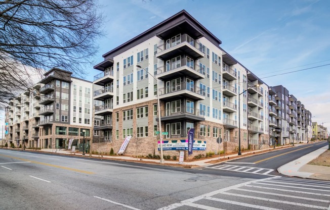 a large apartment building on the corner of a city street