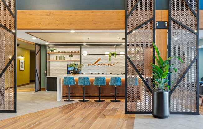 A modern interior with a wooden bar and blue bar stools.