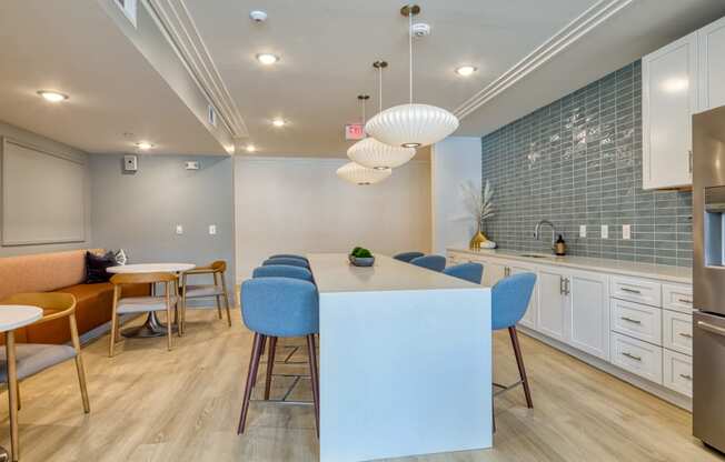 a kitchen and dining room with blue chairs and a white counter at The Bella at Westchester, Midlothian, 23113